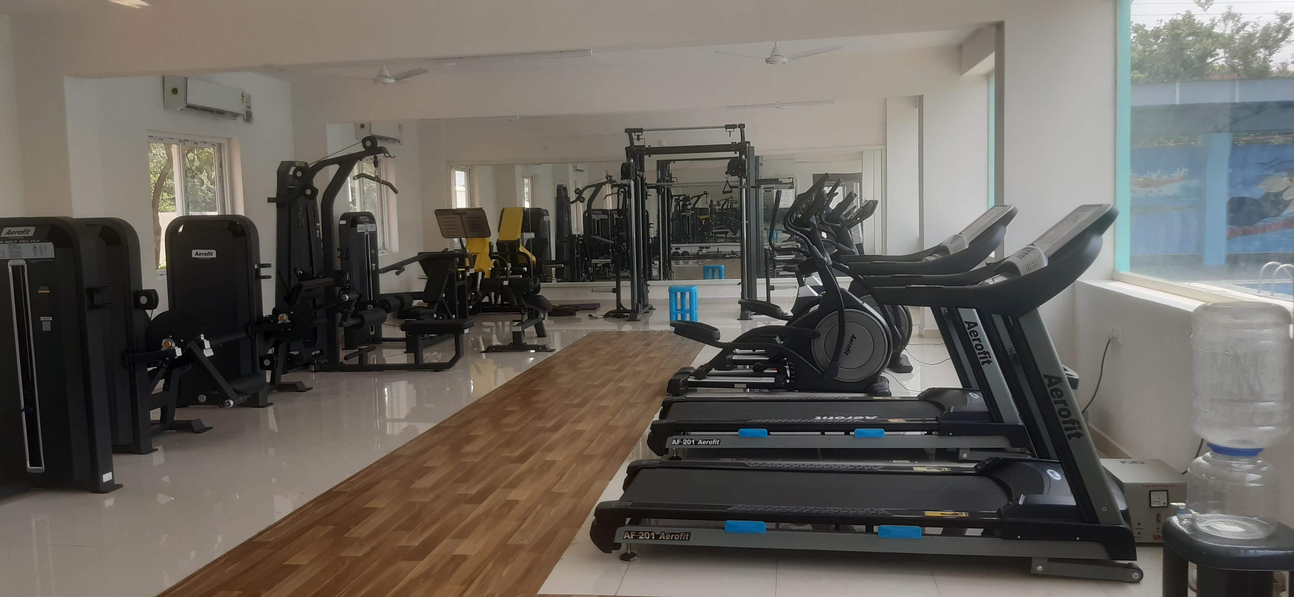 Community gym with cardio and strength equipment at Palm Meadows, Kompally
